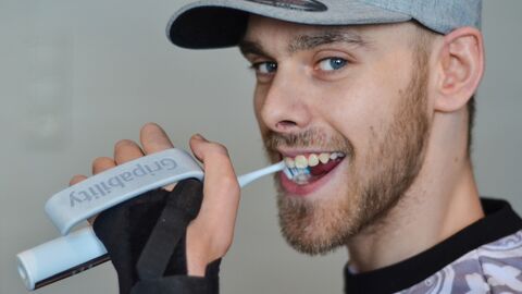 Anerkennung Unternehmen // Gripability t-brush // Zahnbürste mit einem rotationsfähigen Griffbügel Mann mit Cap putzt sich die Zähne