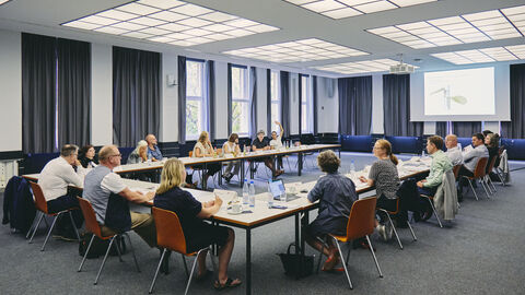 Alle Jurymitglieder sitzen an einem großen Konferenztisch