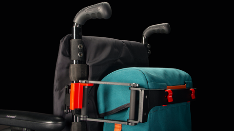 2. Preis Kategorie Newcomer 2024 Die Rückseite eines Rollstuhls ist mit einem Schwenkbügel versehen, an dem die blaue Rollstuhl- bzw. Fahrradtasche befestigt ist.
